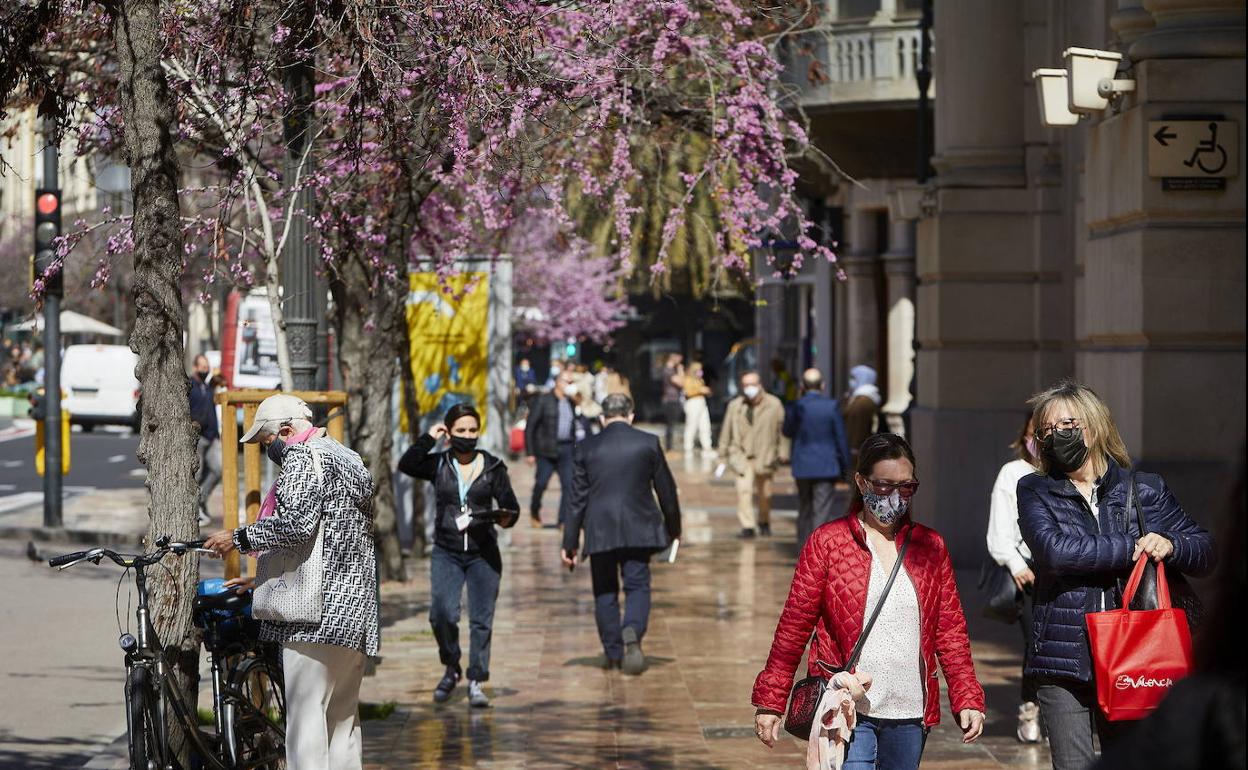 Gente paseando por la calle en un día primaveral en Valencia.