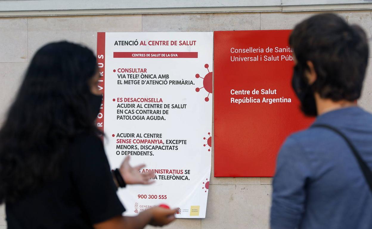 Usuarios leen un cartel informativo a las puertas de un centro de salud valenciano.