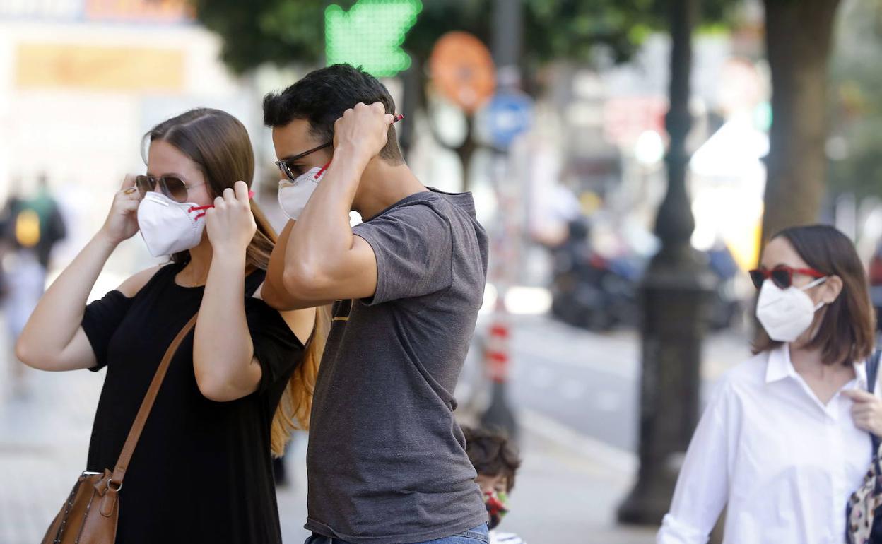 Dos jóvenes se colocan la mascarilla en Valencia