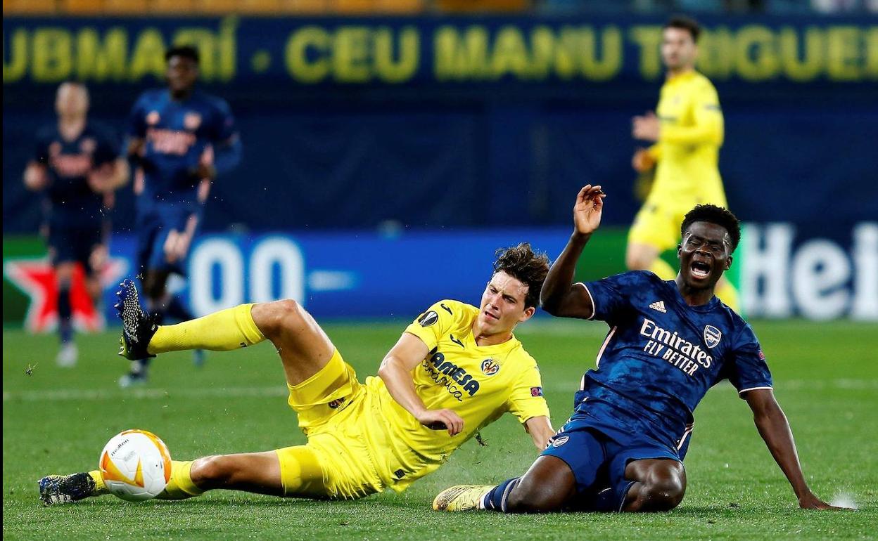 El defensa del Villarreal Pau Torres (i) pelea un balón con el centrocampista ghanés del Arsenal Thomas Partey. 