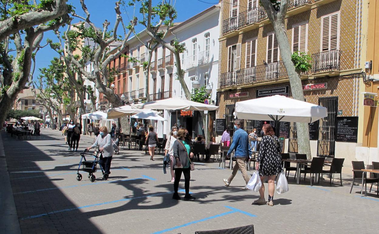 Personas caminando por el centro de la principal arteria de Dénia, la calle Marqués de Campo, cerrada al tráfico desde hace un año. 