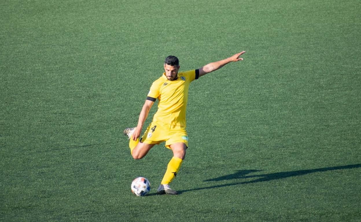 Moisés García golpea el balón durante el partido de este sábado en el Municipal de Badalona. 