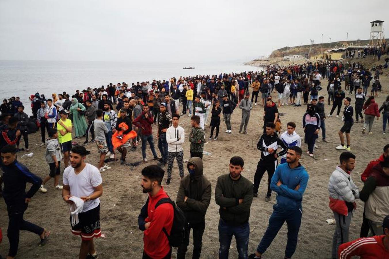 Cientos de personas esperan en la playa de la localidad de Fnideq (Castillejos) para cruzar los espigones de Ceuta.