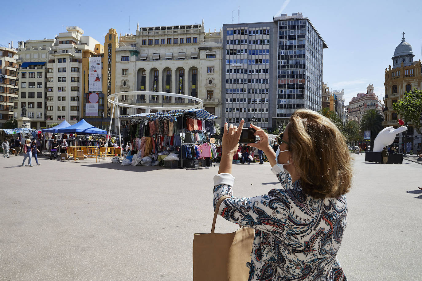 Protestas, mercadillos y restos de instalaciones se mezclan junto a la plaza del Ayuntamiento. Comerciantes y vecinos de la zona insisten en los problemas para acceder en coche mientras el monolito del 15M sigue protegido por vallas.