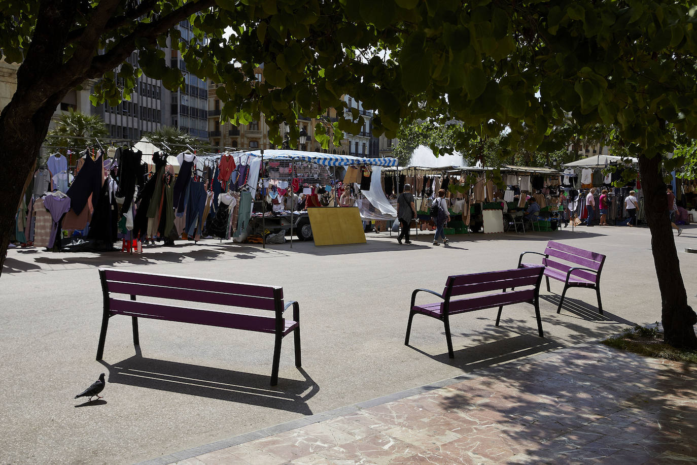 Protestas, mercadillos y restos de instalaciones se mezclan junto a la plaza del Ayuntamiento. Comerciantes y vecinos de la zona insisten en los problemas para acceder en coche mientras el monolito del 15M sigue protegido por vallas.