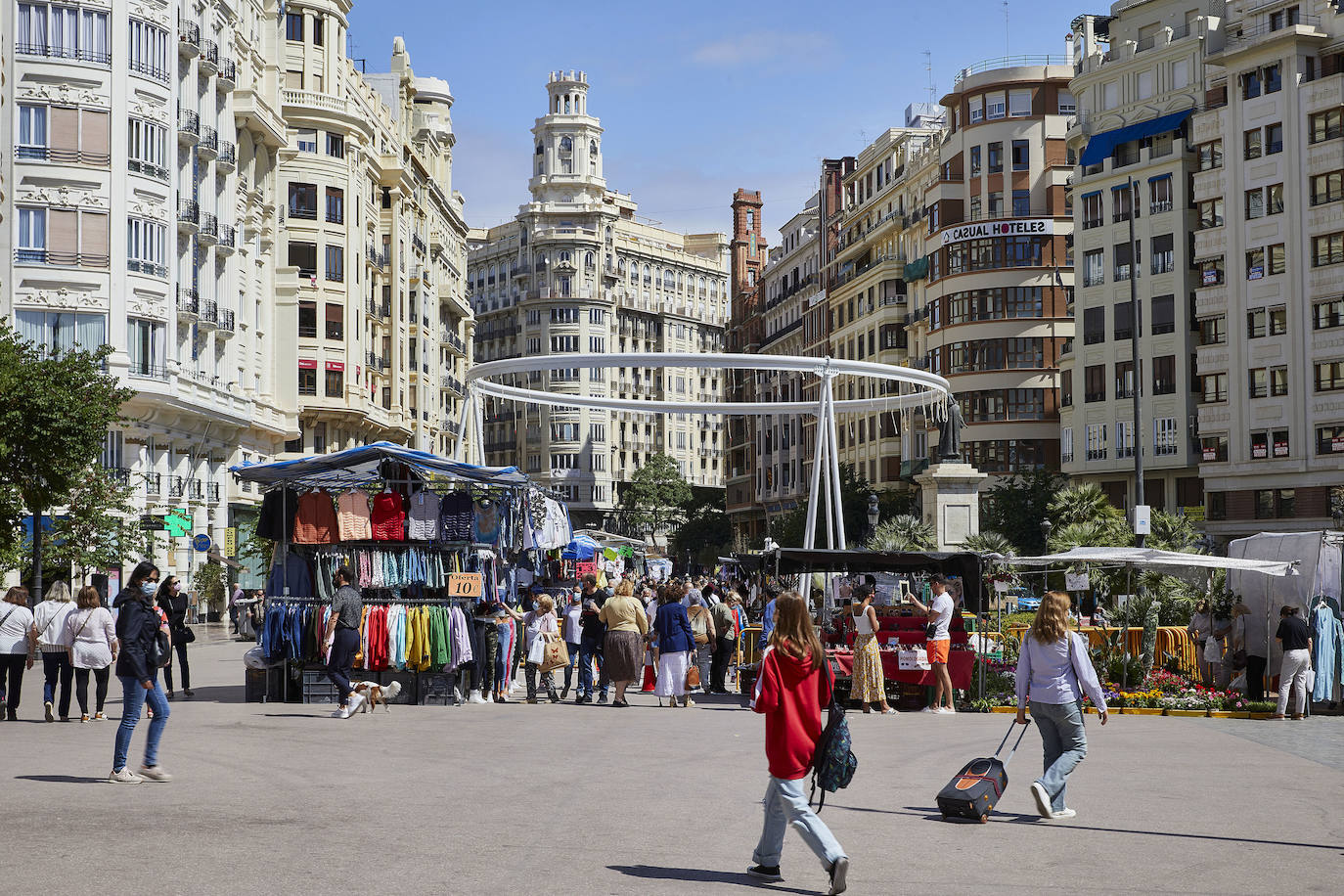 Protestas, mercadillos y restos de instalaciones se mezclan junto a la plaza del Ayuntamiento. Comerciantes y vecinos de la zona insisten en los problemas para acceder en coche mientras el monolito del 15M sigue protegido por vallas.