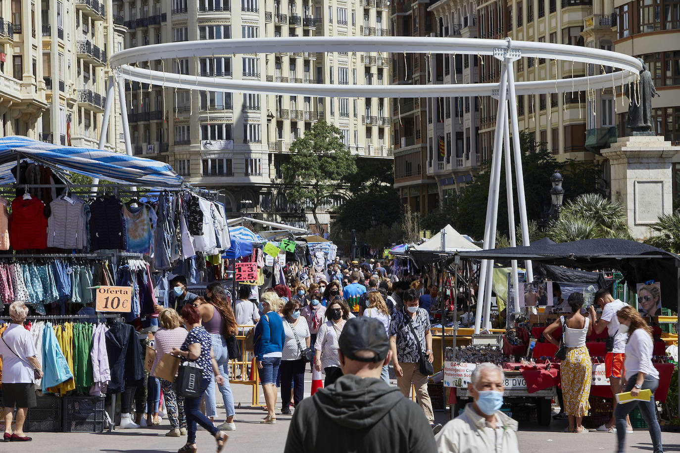 Protestas, mercadillos y restos de instalaciones se mezclan junto a la plaza del Ayuntamiento. Comerciantes y vecinos de la zona insisten en los problemas para acceder en coche mientras el monolito del 15M sigue protegido por vallas.