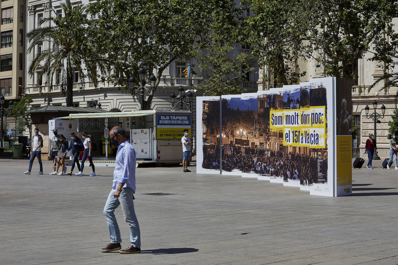 Protestas, mercadillos y restos de instalaciones se mezclan junto a la plaza del Ayuntamiento. Comerciantes y vecinos de la zona insisten en los problemas para acceder en coche mientras el monolito del 15M sigue protegido por vallas.