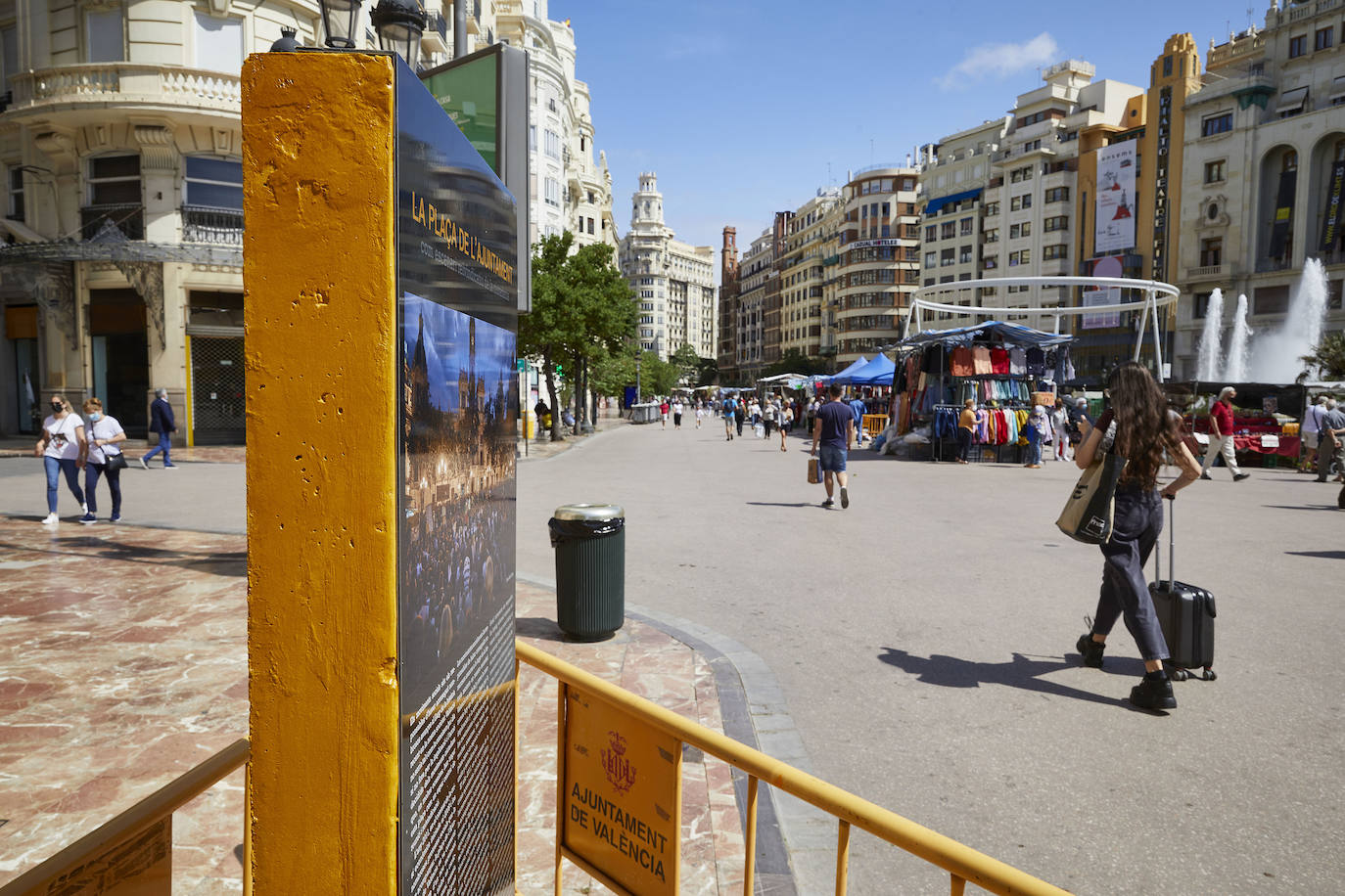 Protestas, mercadillos y restos de instalaciones se mezclan junto a la plaza del Ayuntamiento. Comerciantes y vecinos de la zona insisten en los problemas para acceder en coche mientras el monolito del 15M sigue protegido por vallas.