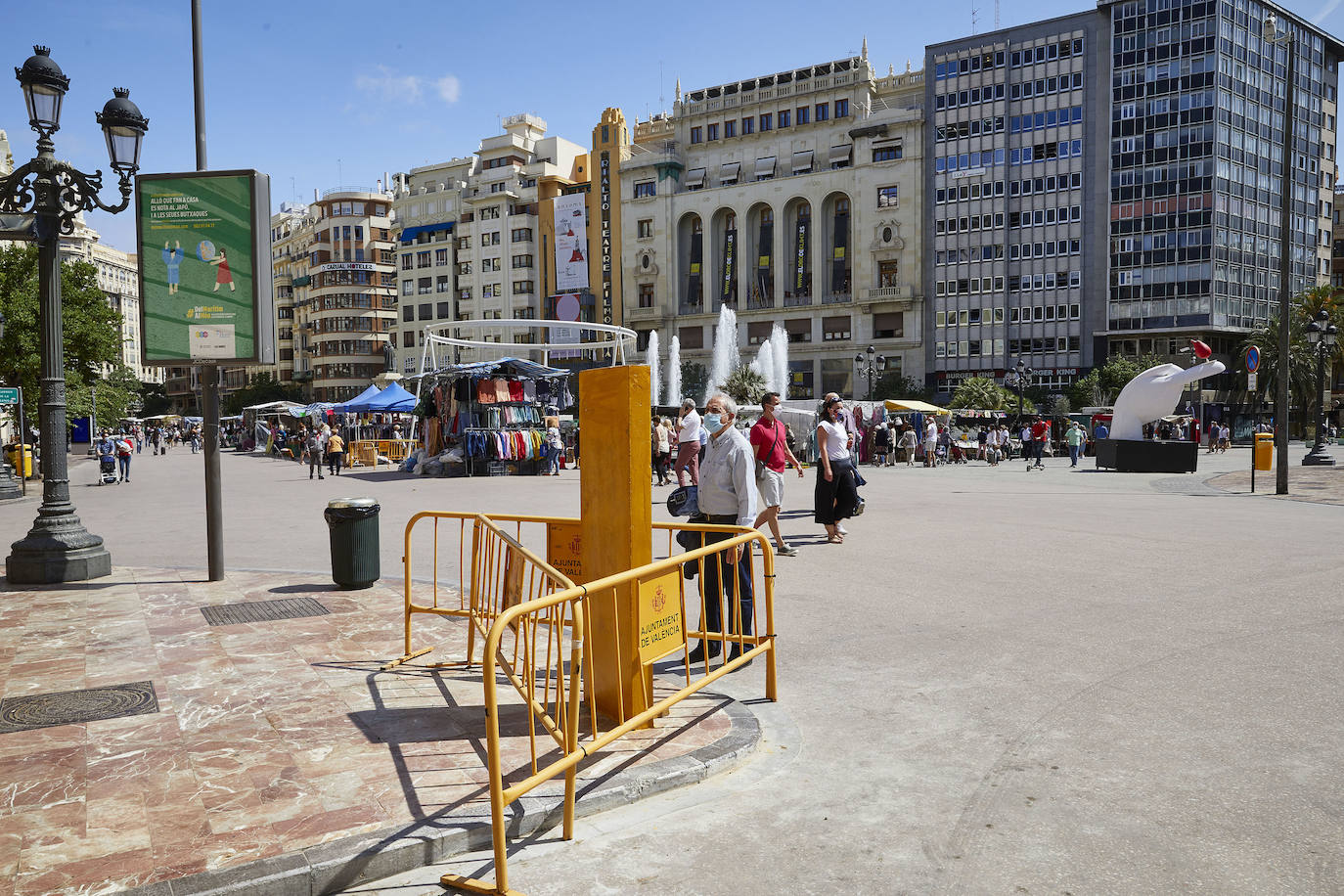 Protestas, mercadillos y restos de instalaciones se mezclan junto a la plaza del Ayuntamiento. Comerciantes y vecinos de la zona insisten en los problemas para acceder en coche mientras el monolito del 15M sigue protegido por vallas.