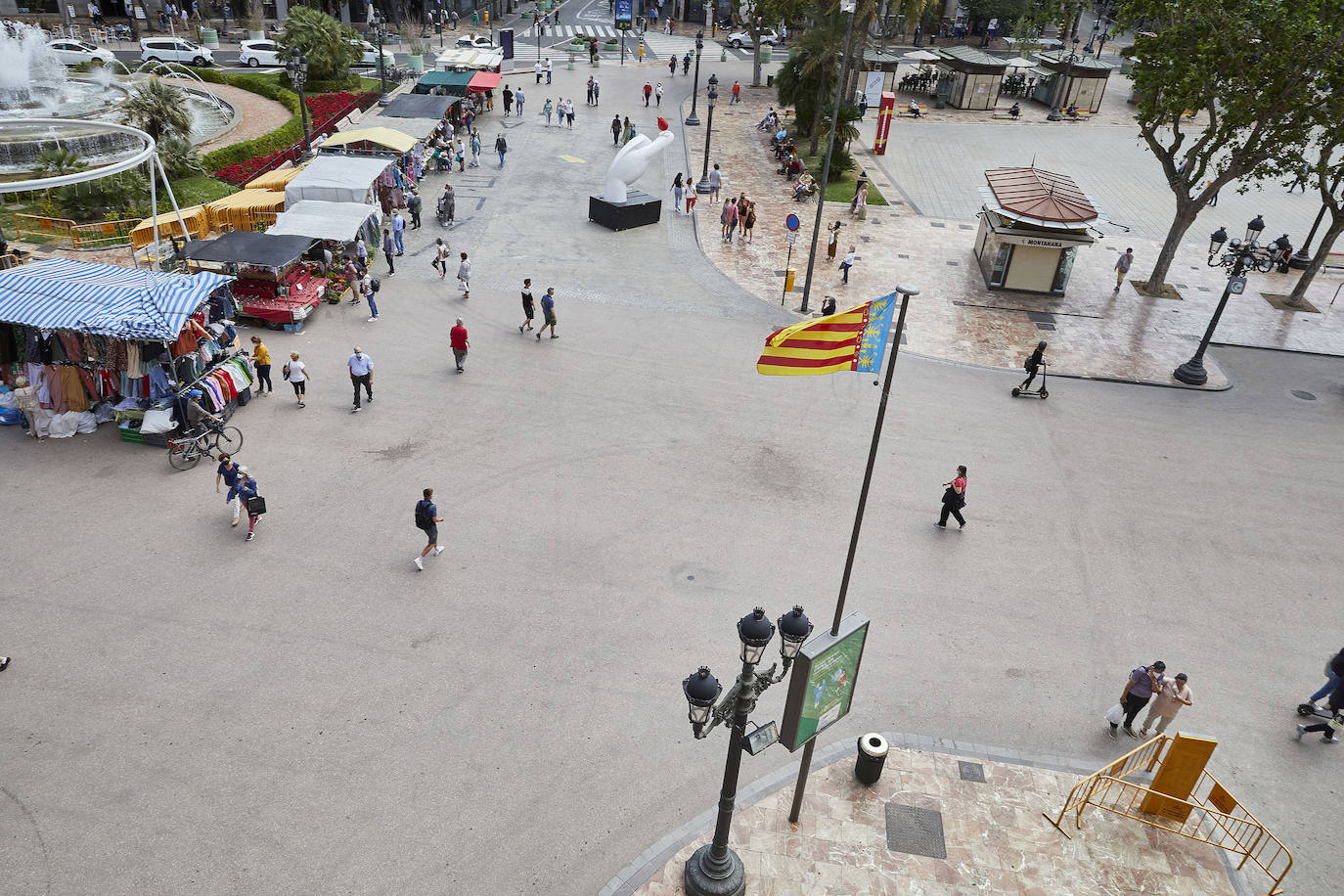 Protestas, mercadillos y restos de instalaciones se mezclan junto a la plaza del Ayuntamiento. Comerciantes y vecinos de la zona insisten en los problemas para acceder en coche mientras el monolito del 15M sigue protegido por vallas.