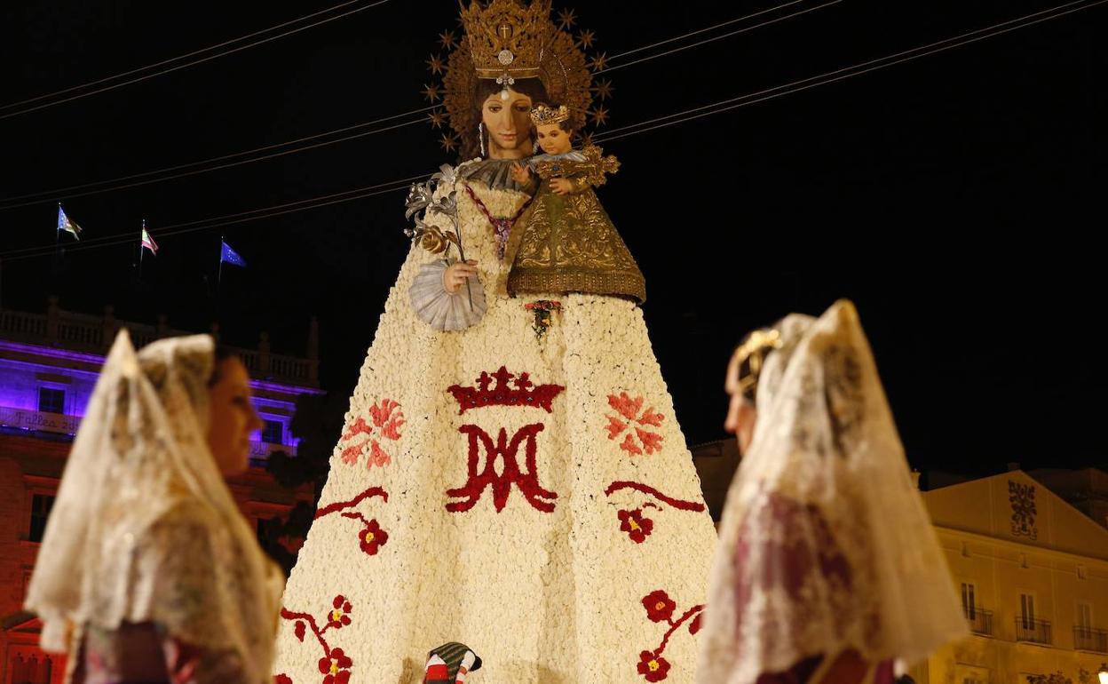 Dos falleras con templan el manto floral de la Virgen. 