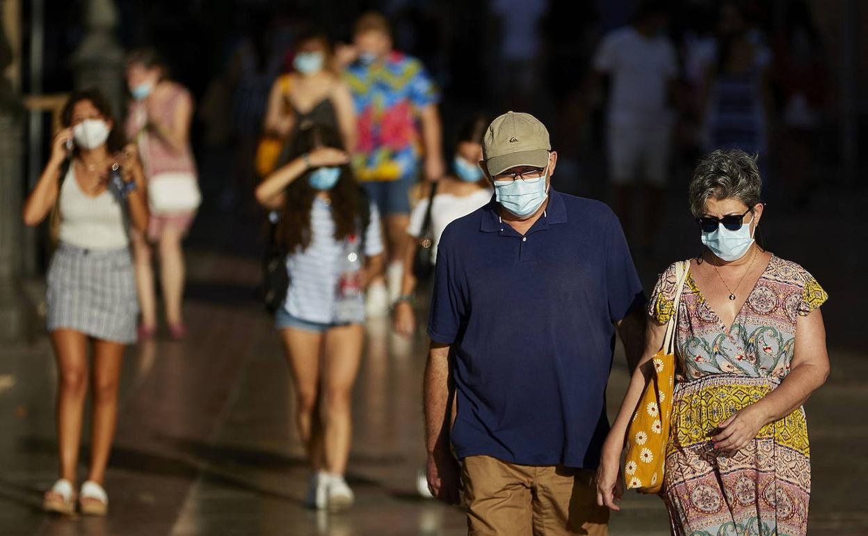 Varias personas paseando por las calles de Valencia. 