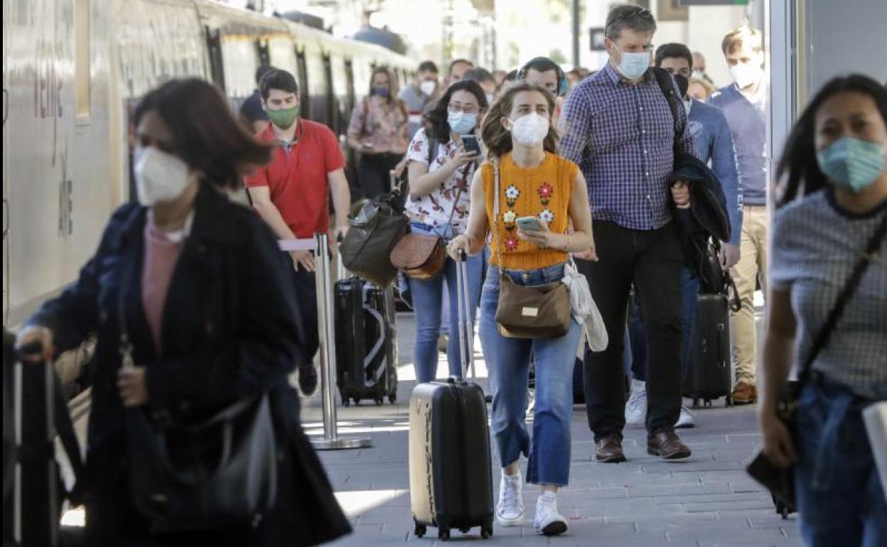 Varias personas en una estación de tren de Valencia.