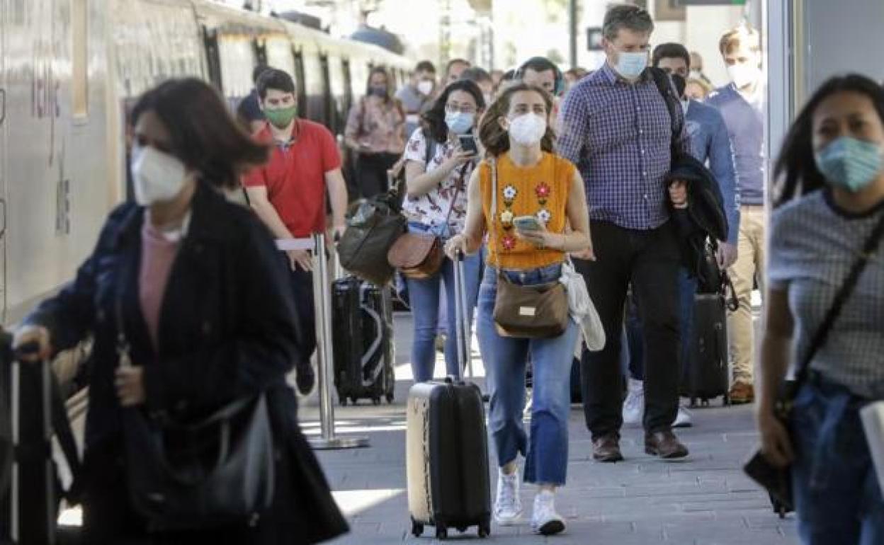 Varias personas en una estación de tren de Valencia.