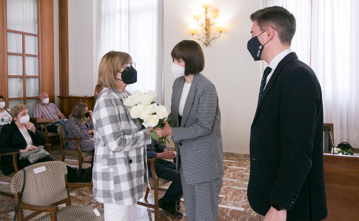 La alcaldesa Diana Morant entrega un ramo de flores a la viuda de Toni Rodríguez, en presencia del edil del PP Víctor Soler.  