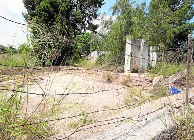 Imagen secundaria 1 - Caseta del perro. 'Erty' era el nombre de la perra con la que convivía la pareja y sus hijos en la parcela. (Damián Torres) | Ruina. En esta deteriorada nave próxima a la casa también jugaban los niños. Todavía hay dentro juguetes que penden de una cuerda. (Damián Torres) | Vecinos y amigos de la familia honran el recuerdo de los menores con juguetes, flores y rosarios en su nicho.