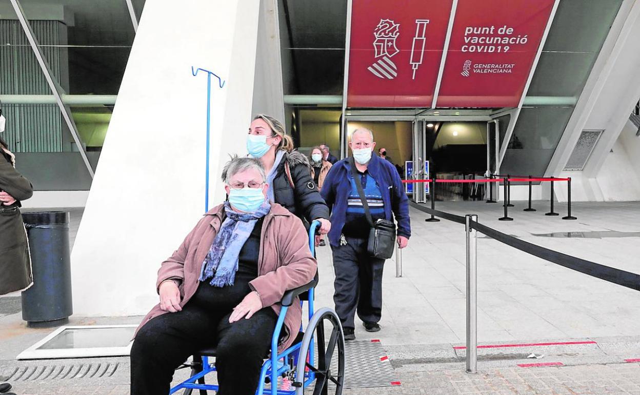 Varias personas salen del centro de vacunación masiva de la Ciudad de las Artes y las Ciencias.