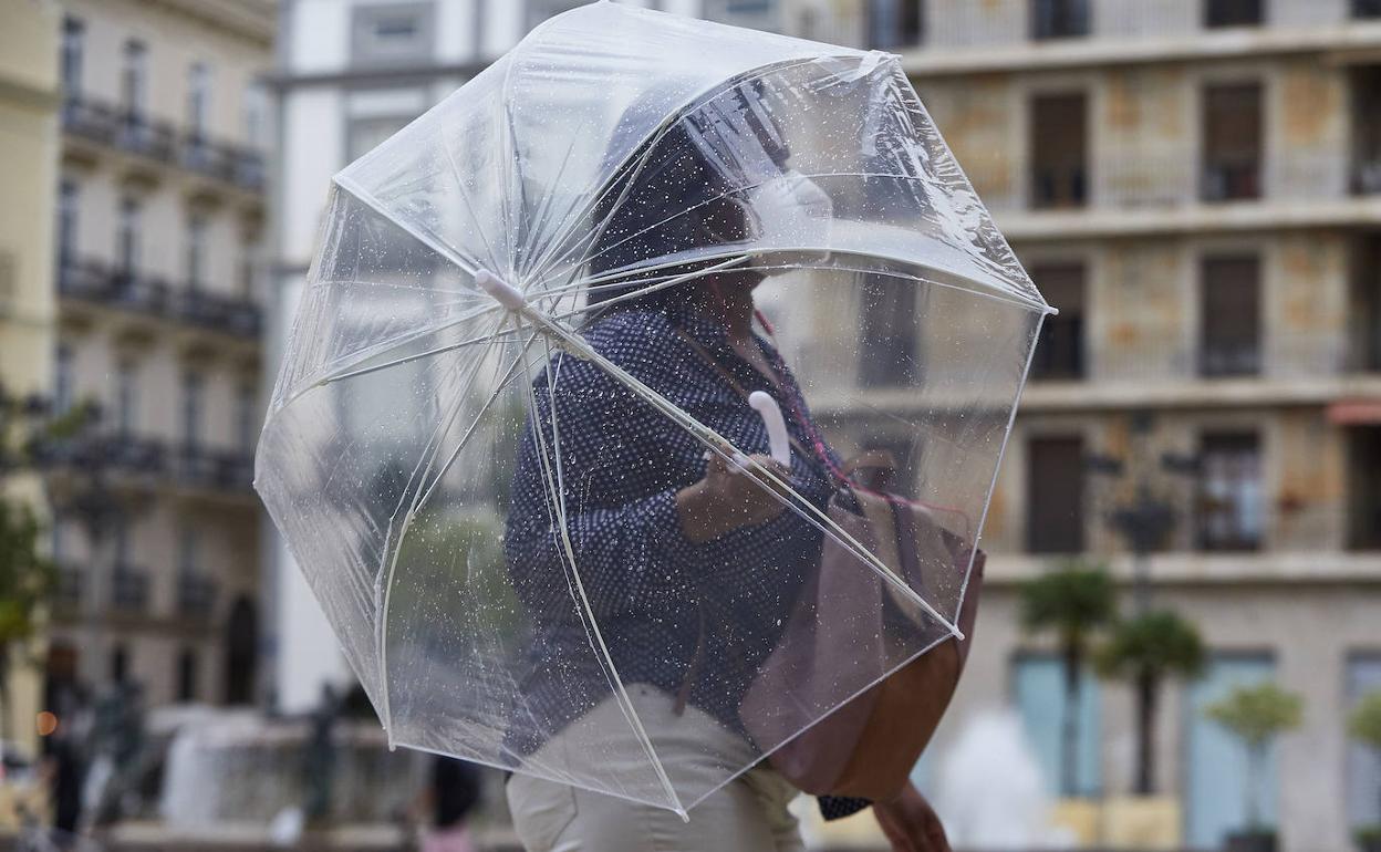 Una mujer se protege de la lluvia en Valencia. 