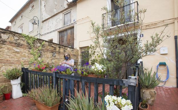 Imagen principal - Sempere. Patricia Lea atiende el jardín de su casa en Sempere. Ella, como la mayoría de sus vecinos, está vacunada. | En Vallés los vecinos acuden al reparto de pan diario.