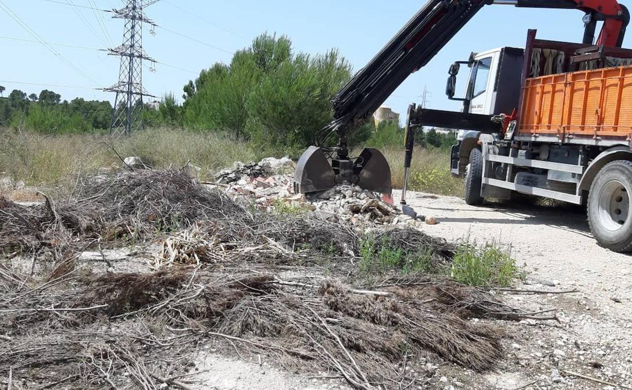 Operarios retiran los restos de basura en la urbanización Convent de les Monges.