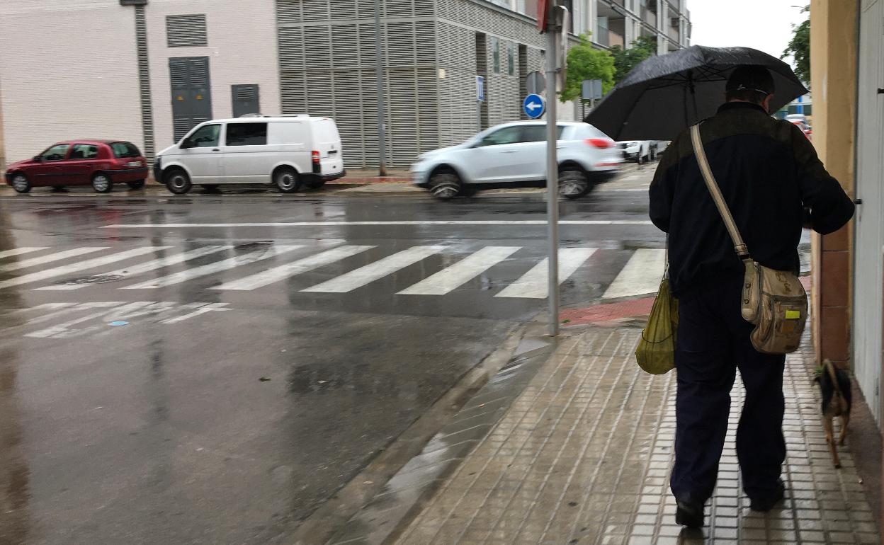 Un vecino de Gandia camina un día de lluvia. 