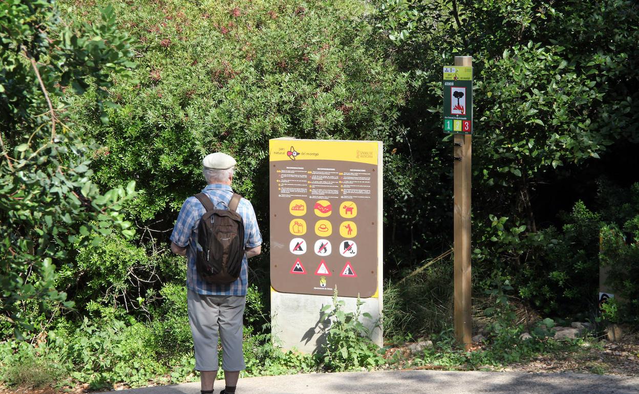 Un hombre leyendo las recomendaciones del parque natural del Montgó. 