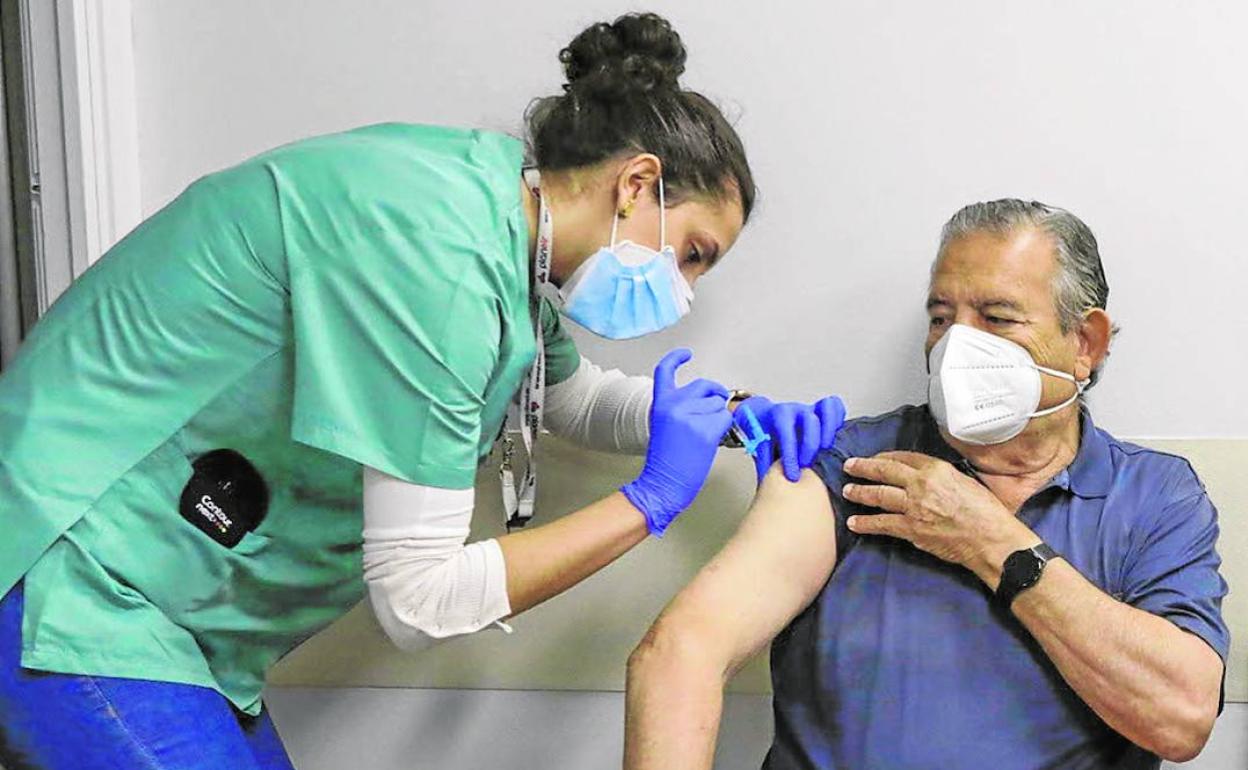 Personal sanitario administra una dosis de la vacuna contra el Covid a un paciente.