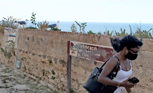 Una turista de visita en el Castillo de Dénia tomado por las gaviotas desde hace años. 