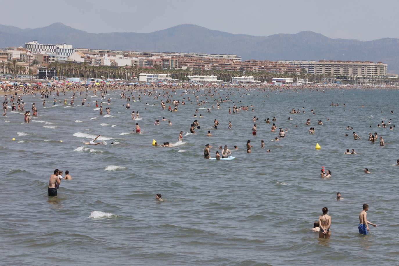 El buen tiempo y el fin de semana han dejado imágenes de las playas de Valencia llenas de gente. Muchas personas se han decantado por practicar algún deporte acuático, mientras que otras han preferido tomar el sol en la arena, donde costaba encontrar un sitio en el que plantar la sombrilla y la toalla. 