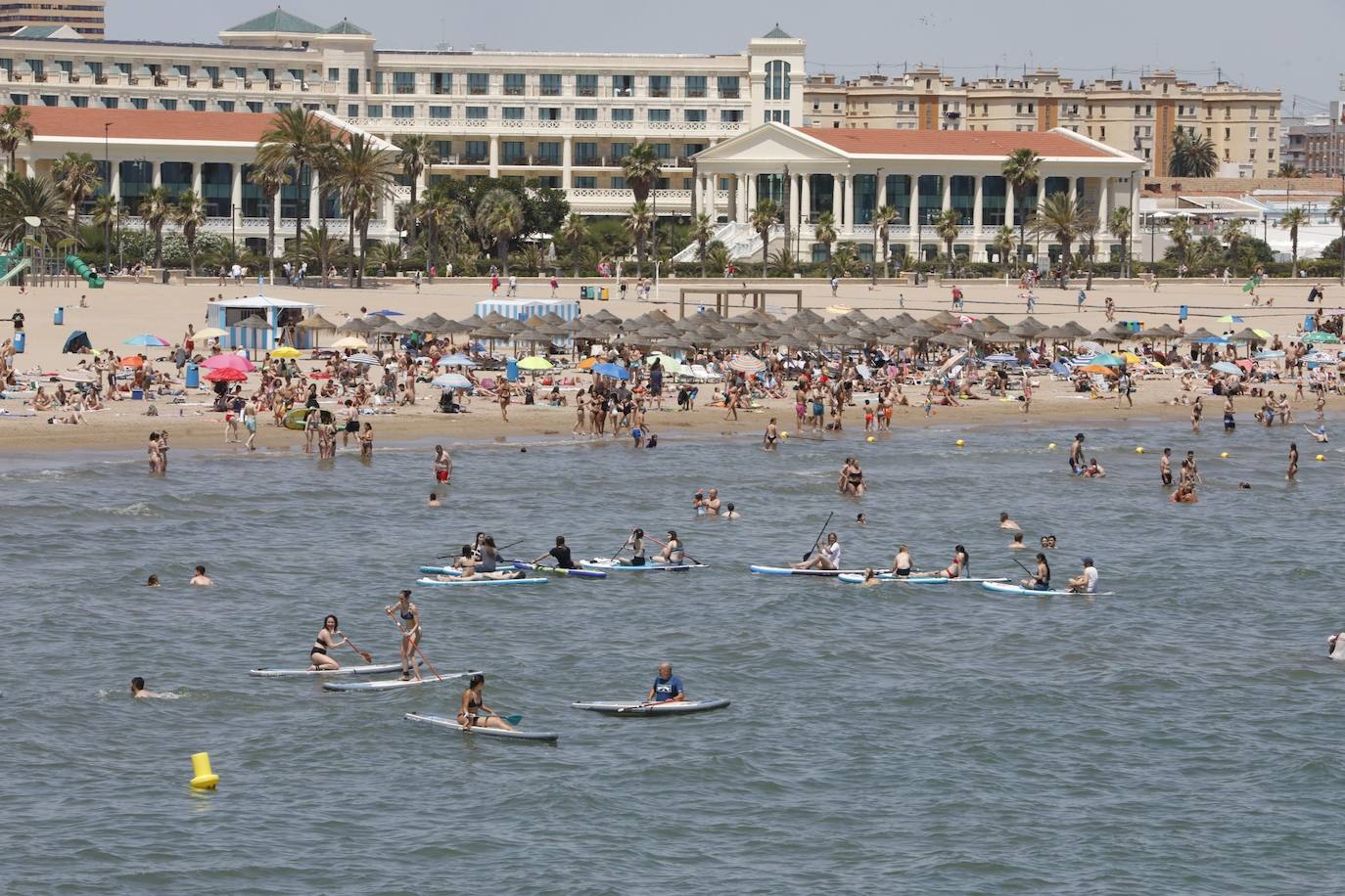 El buen tiempo y el fin de semana han dejado imágenes de las playas de Valencia llenas de gente. Muchas personas se han decantado por practicar algún deporte acuático, mientras que otras han preferido tomar el sol en la arena, donde costaba encontrar un sitio en el que plantar la sombrilla y la toalla. 