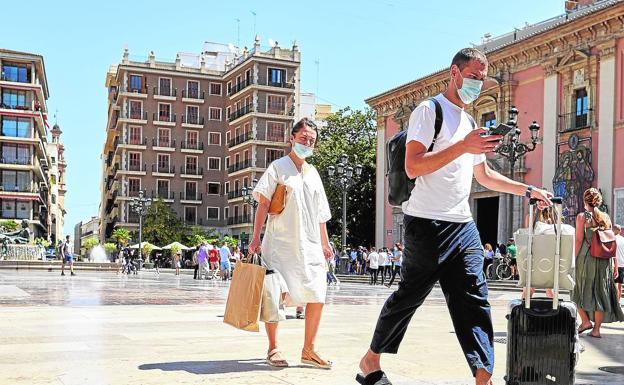 Imagen principal - La plaza de la Virgen de Valencia y las terrazas de los restaurantes, llenas de turistas.