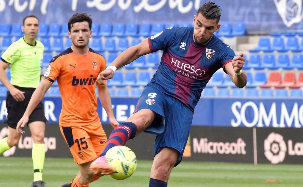 Rafa Mir controla el balón ante la presión de Hugo Guillamón en el último partido de la temporada 2020-2021 en El Alcoraz