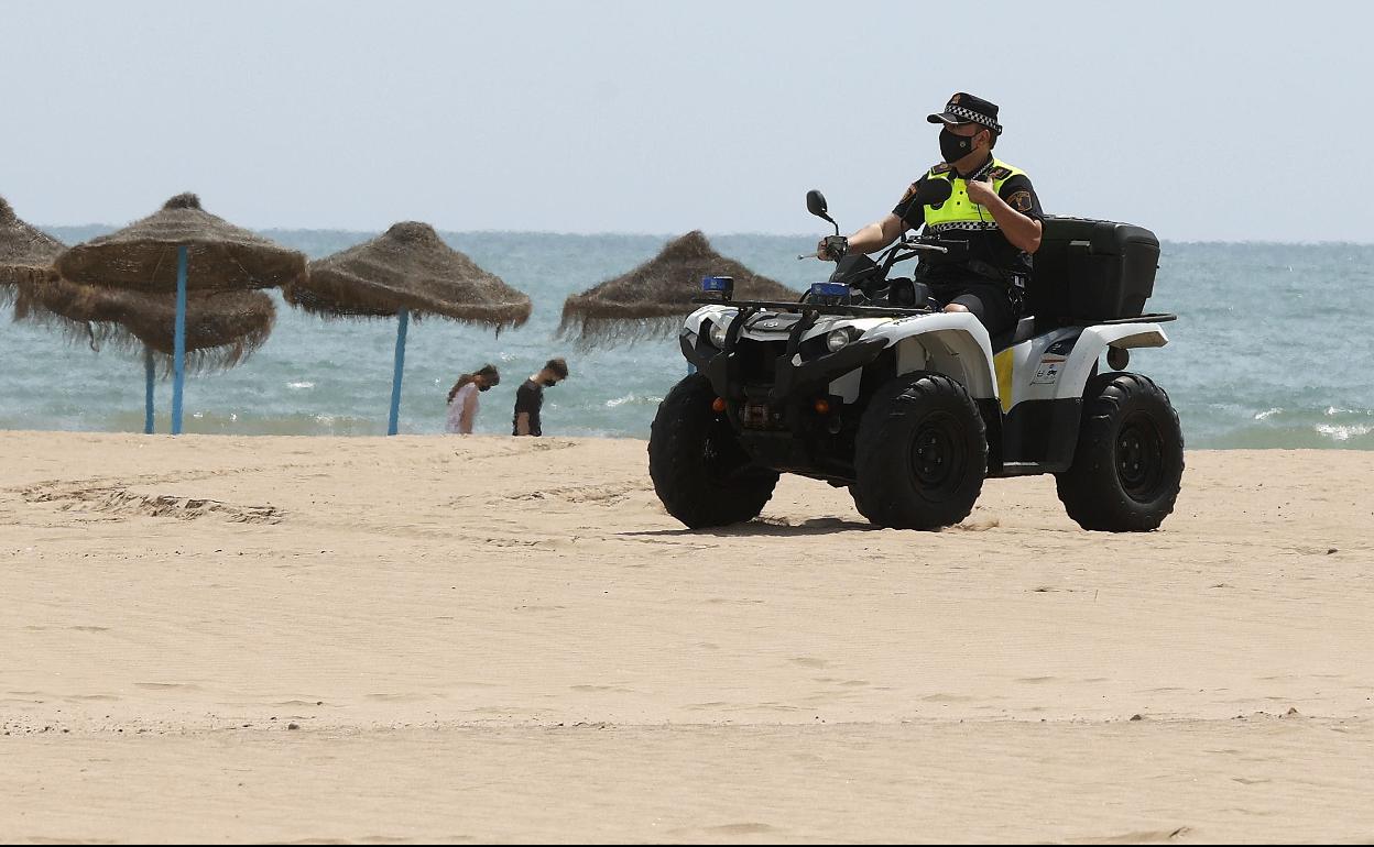 Dos agentes de Policía Local vigilan la playa de la Malvarrosa.