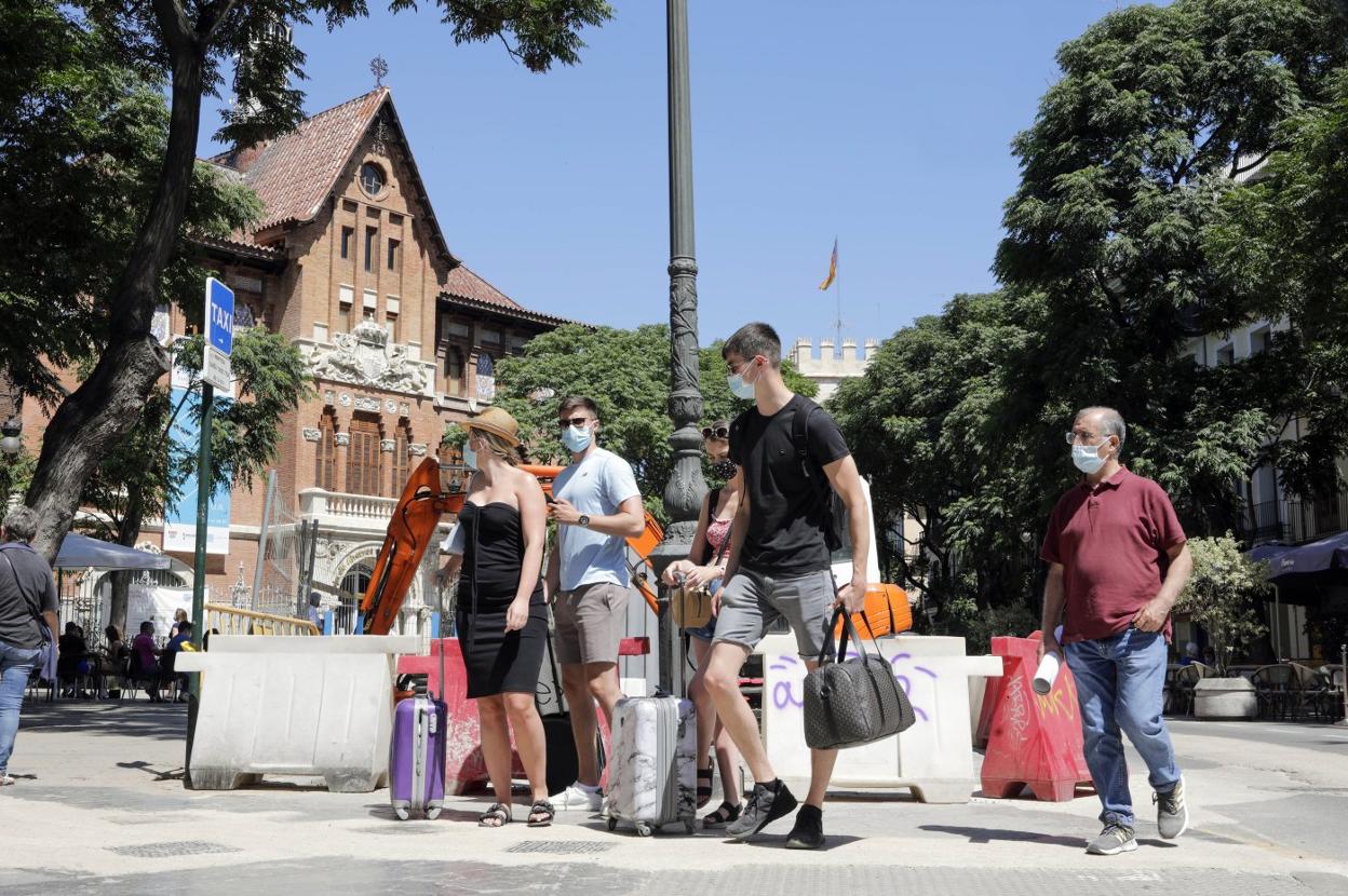 Maletas. Un grupo de turistas sortea parte de las obras en la plaza del Mercado ayer por la mañana. irene marsilla