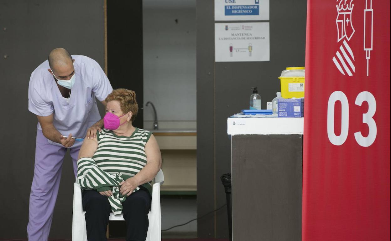 Personal sanitario administra una dosis de la vacuna en Requena.