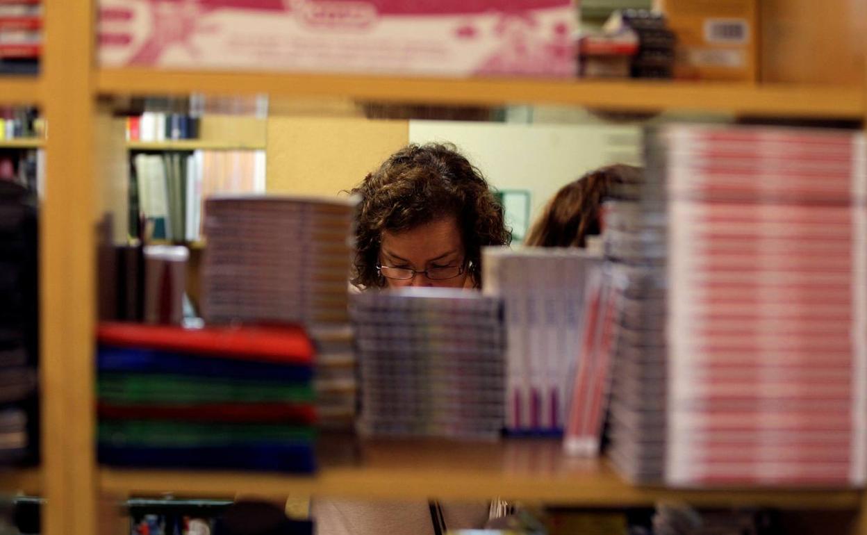 Una mujer comprando material escolar en una librería, en una foto de archivo. 