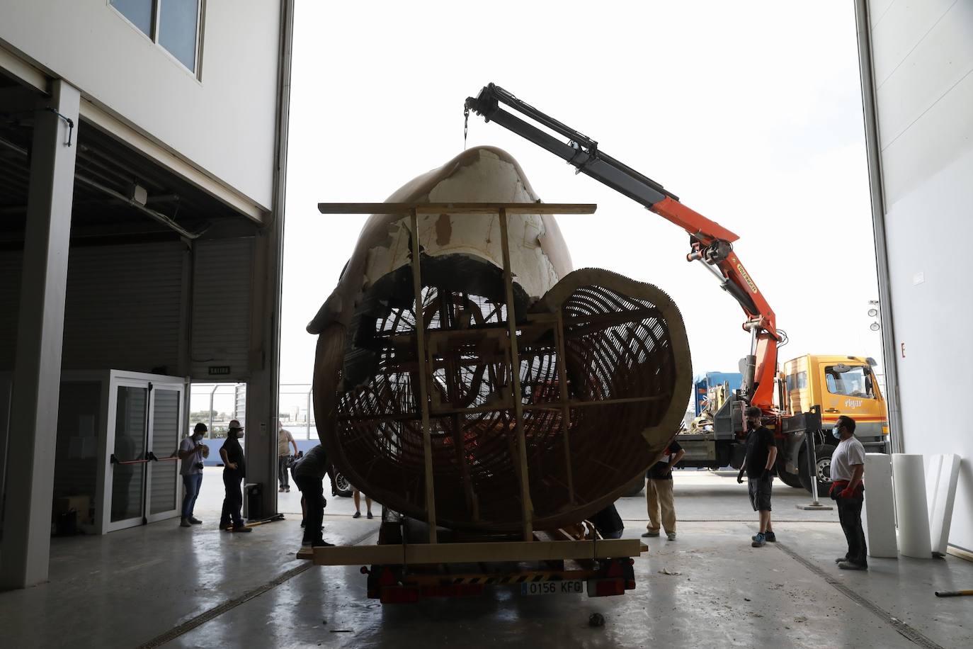 El busto de la falla municipal 2020 sale de la antigua base del Alinghi en La Marina para su restauración. 