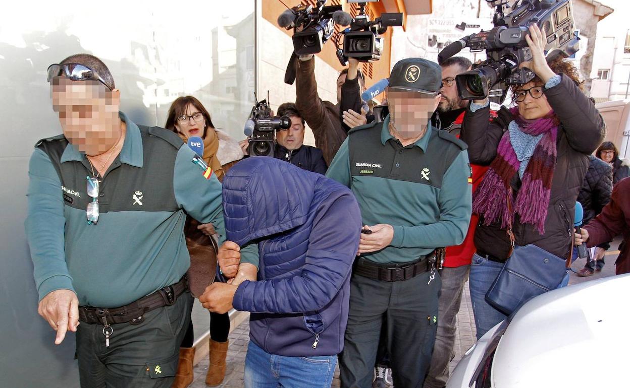 Dos agentes de la Guardia Civil de Alicante trasladan a uno de los sospechosos de la agresión sexual. 