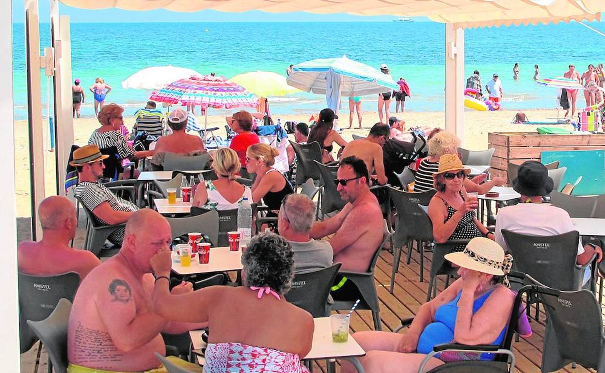 Una terraza llena de clientes en una playa de Dénia. 