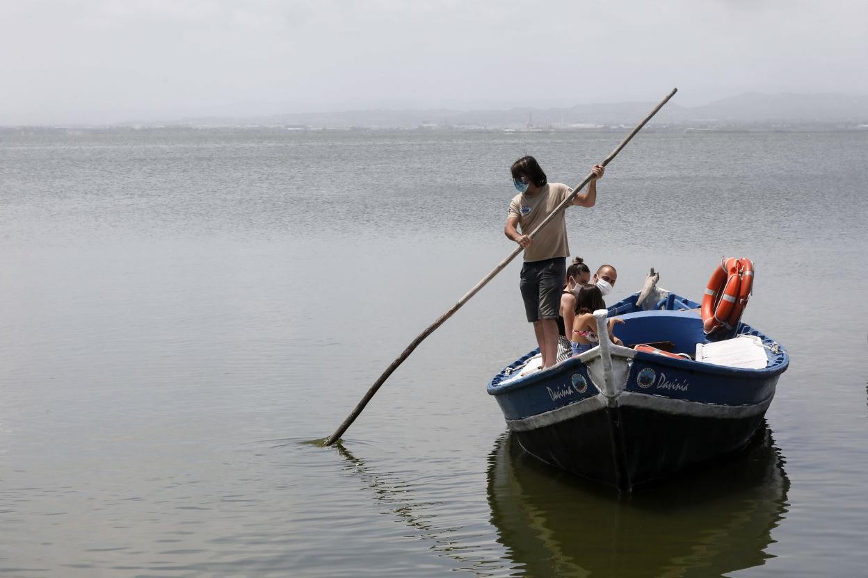 Una barca pasea por la Albufera con varios ocupantes. irene marsilla