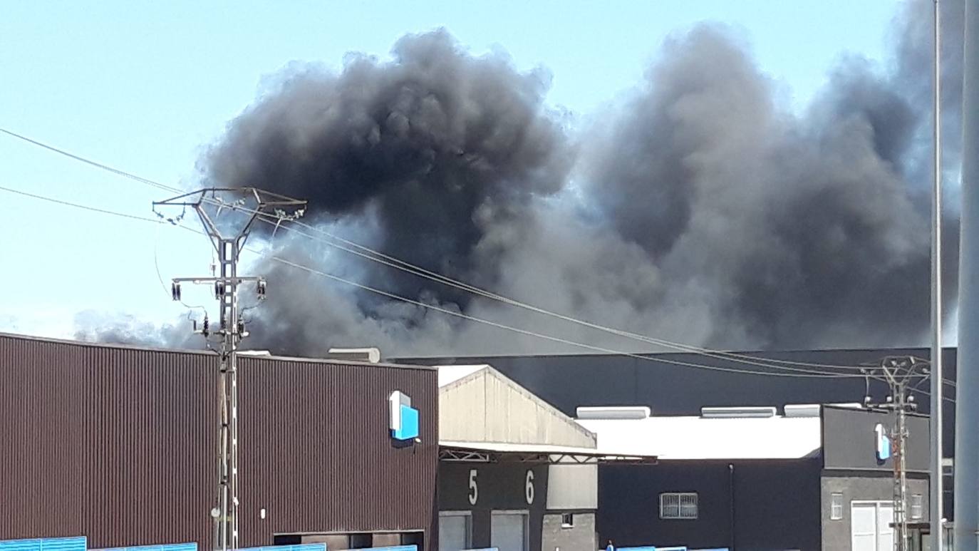 El fuego se ha iniciado este martes por la mañana y al ser una nave donde se trabaja con pinturas y barnices se ha generado una intensa columna de humo gris visible desde varios kilómetros. Los bomberos trabajan en su control para que no se propague.