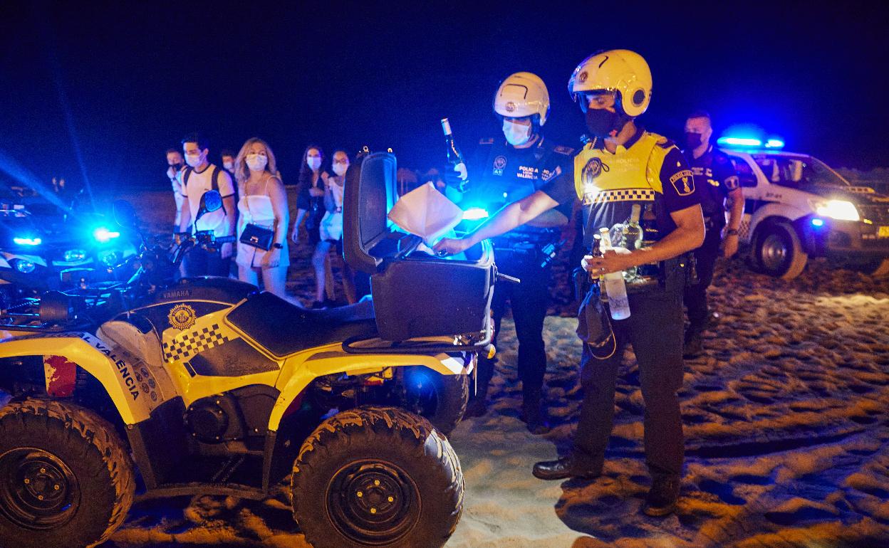 La policía actúa en un botellón en la playa de Valencia.