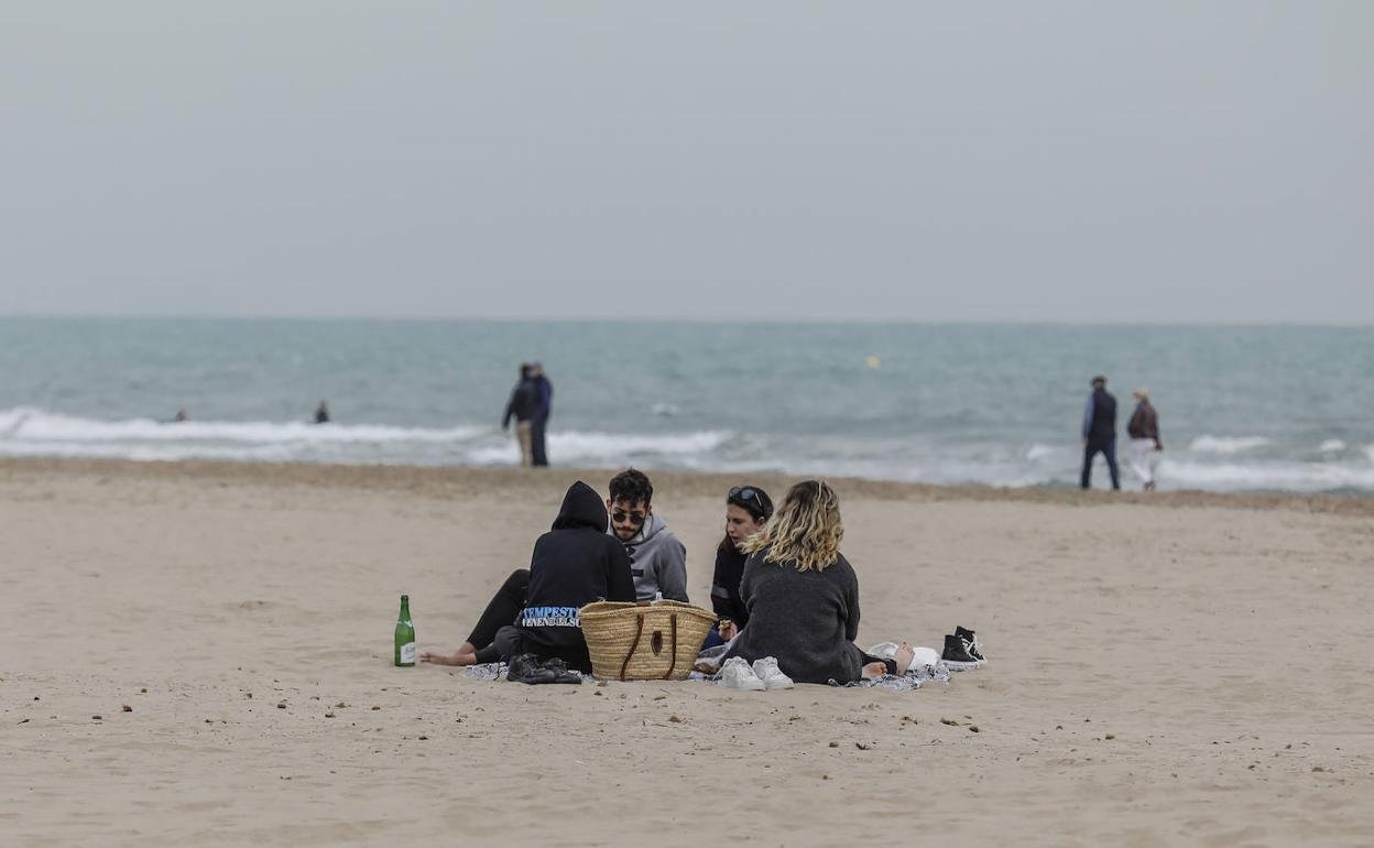 Un grupo de jóvenes en la playa de la Malvarrosa.