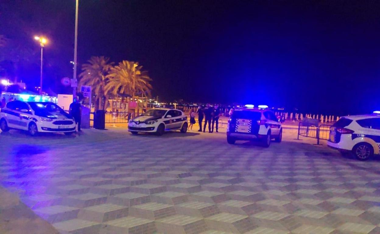 Agentes de la Policía Local de Alicante vigilan la playa del Postiguet desde el paseo. 