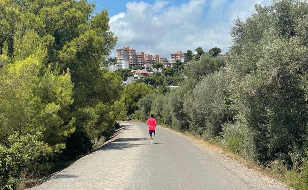 Al fondo. los edificios de la localidad de Benicàssim al fin de la vía verde. 