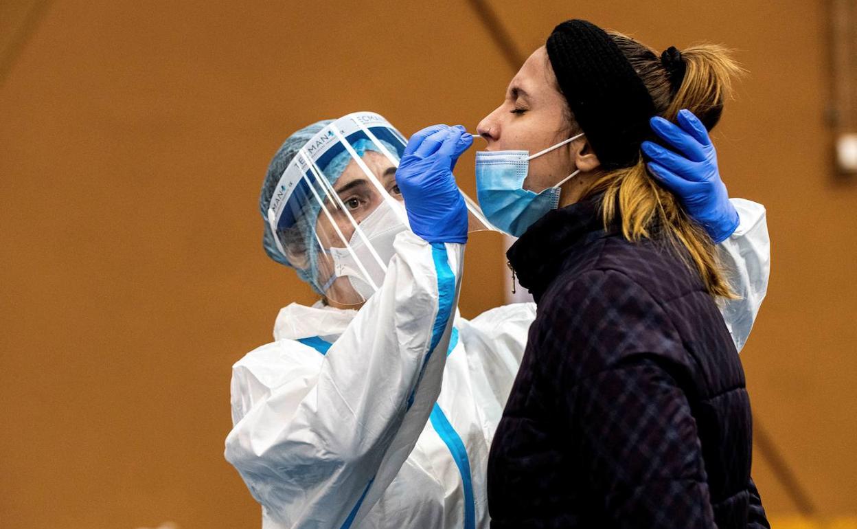 Una sanitaria realiza una PCR a una paciente.