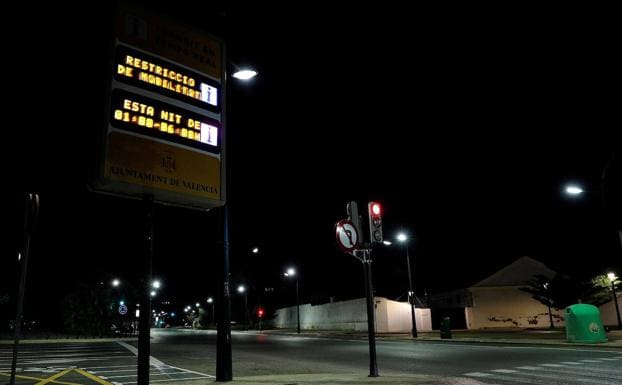 Un letrero luminoso señala el horario del toque de queda en Valencia. 