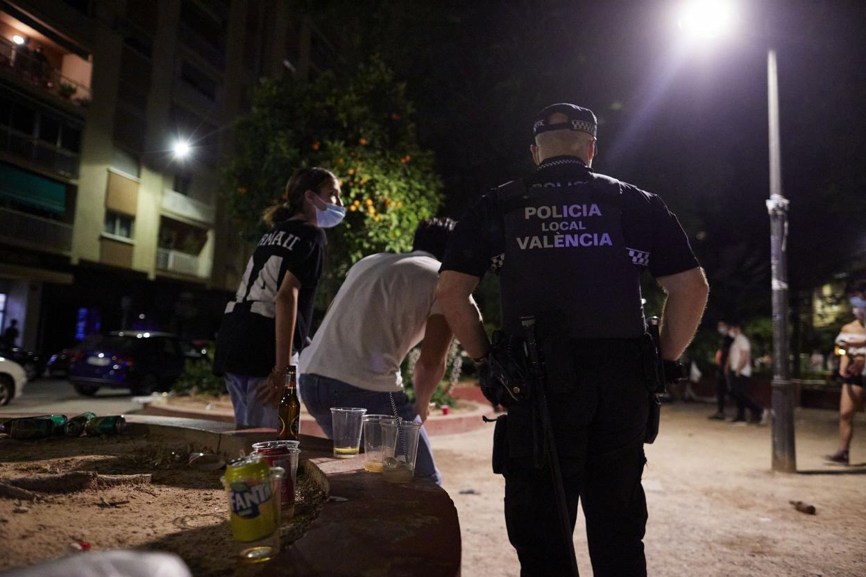 Un policía desmantela un botellón en la plaza de Honduras de Valencia . iván arlandis