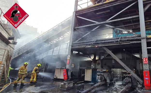 Los bomberos trabajan en las tareas de extinción del incendio. 